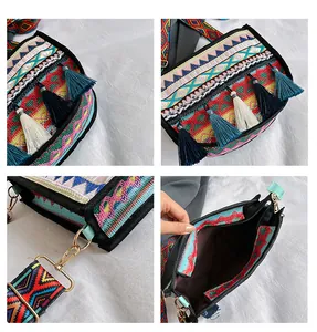 Detail view of ethnic embroidery, colorful tassels and wide strap on bohemian crossbody bag