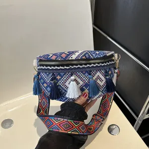 Détail du sac banane bohème avec motifs géométriques colorés et franges bleues