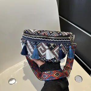 Détail d'un sac bandoulière tissé bohème avec motifs colorés et glands en soie