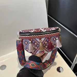 Détail du tissage jacquard ethnique et des glands colorés sur un sac bandoulière bohème