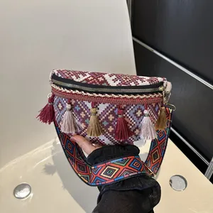 Détail d'un sac banane ethnique tissé avec glands colorés et motifs géométriques