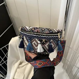 Détail d'un sac à bandoulière ethnique tissé avec pompons et broderie géométrique