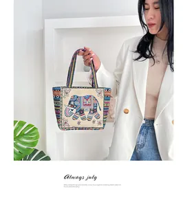 Close-up of vintage ethnic handbag featuring elephant embroidery and geometric weave