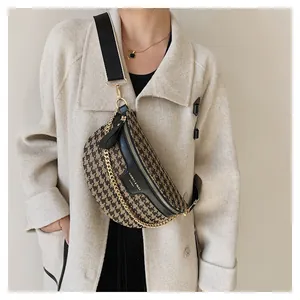 Detail der Houndstooth-Umhängetasche mit Goldkette und verstellbarem Riemen am Model