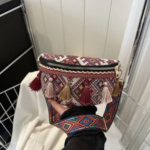 Détail du sac banane bohème montrant le tissage jacquard ethnique et les glands colorés