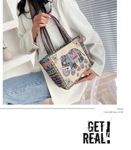 Detailed close-up of ethnic canvas tote bag with elephant embroidery and colorful straps