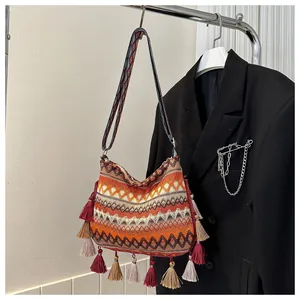 Detail of bohemian woven crossbody bag with colorful tassels and geometric patterns