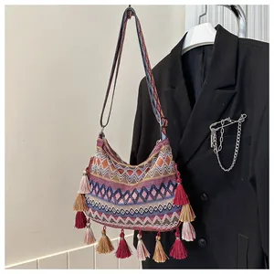 Detailed close-up of Bohemian woven shoulder bag featuring colorful tassels and geometric patterns