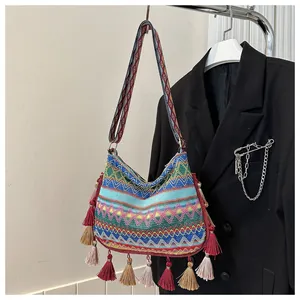 Close-up of bohemian woven crossbody bag with colorful tassels and geometric patterns