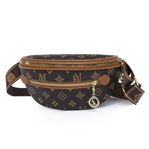 Dettaglio del marsupio marrone con monogramma, hardware dorato e tracolla in tessuto