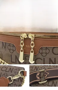 Detail of high-gloss gold zippers and chain strap on brown monogram crossbody bag