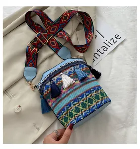 Dettaglio della borsa a secchiello etnica con ricami colorati e nappe con frange blu