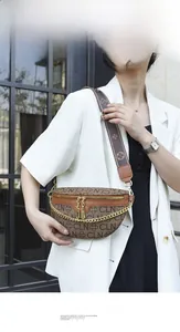Detail of vintage monogram fanny pack with gold chain and wide strap on white blazer