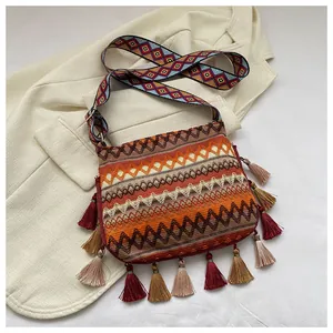 Close-up of bohemian woven bag with colorful geometric patterns and decorative fringe tassels