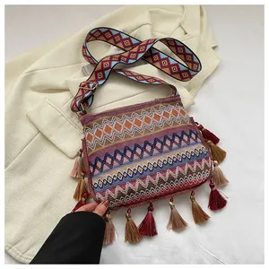 Detail of bohemian crossbody bag featuring colorful embroidery and stylish fringe accents