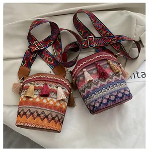 Dettaglio di borse a secchiello boho con ricami geometrici e spalline con nappe