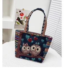 Detail of vintage navy knit bag with owl embroidery and colorful striped strap