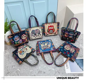 Detail of ethnic canvas tote bags with colorful owl and elephant embroidery patterns