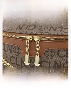 Detail view of the golden metal zipper and chain on the monogram patterned leather bag
