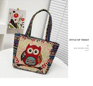 Close-up of ethnic owl embroidery and maple leaves on a woven fabric handbag