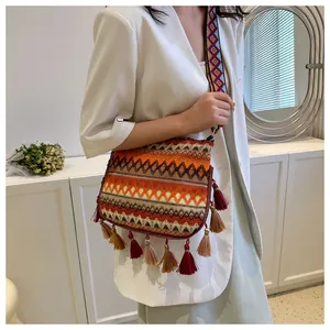 Detailed close-up of bohemian jacquard crossbody bag with fringe and wide woven strap