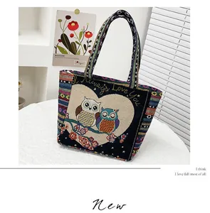 Detail of vintage tote bag with owl embroidery and colorful bohemian striped handle