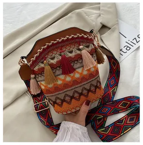 Dettaglio della borsa a secchiello bohémien con motivi intrecciati e nappe colorate