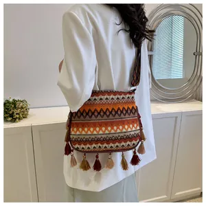 Detailed view of bohemian crossbody bag with colorful tassels and ethnic geometric patterns