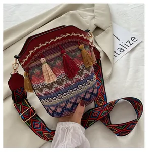 Dettaglio della borsa a secchiello bohémien con ricamo etnico e nappe colorate