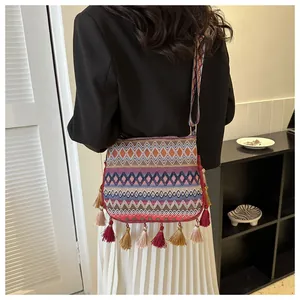 Close-up of bohemian crossbody bag featuring colorful tassels and ethnic pattern strap