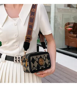 Dettaglio della borsa a tracolla vintage con motivo a rombi e ampia fascia floreale