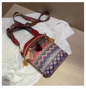 Dettaglio della borsa a secchiello bohémien con trama etnica colorata e nappe rosse