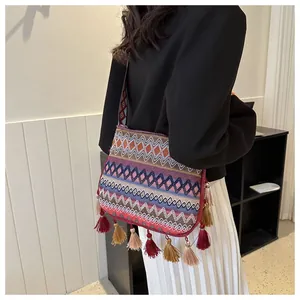 Close-up of bohemian style crossbody bag with colorful patterns and woven fringe tassels
