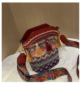 Dettaglio della borsa a secchiello bohémien con trama geometrica, nappe e tracolla ricamata