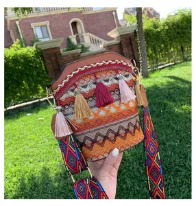 Dettaglio della borsa a secchiello ricamata boho con nappe colorate e tracolla jacquard