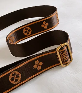 Dettaglio tracolla larga in jacquard con motivo floreale arancione e fibbia dorata