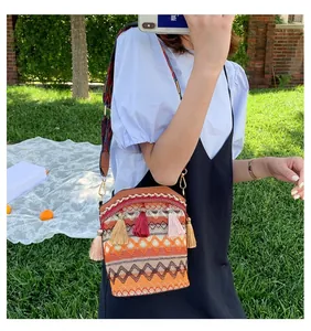 Dettaglio borsa a secchiello boho con ricami etnici e lunghe nappe colorate decorative