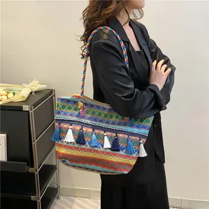 Ethnic woven tote bag with colorful bohemian patterns, blue tassels and rainbow rope straps