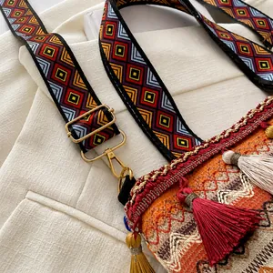 Detail of bohemian embroidery shoulder strap with tassel and gold metal buckle