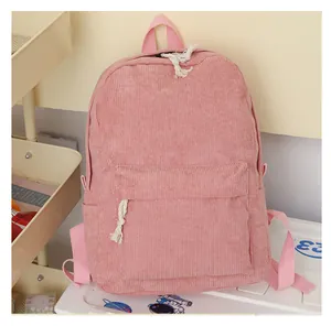 Detailed view of pink corduroy backpack texture with zipper pocket and white rope details