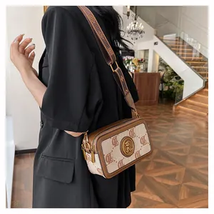 Borsa fotografica vintage marrone con ampia tracolla in tessuto indossata da modella
