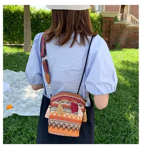 Dettaglio della borsa a secchiello boho con frange colorate e tracolla ricamata larga
