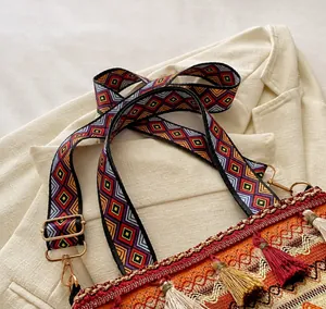 Detail of colorful geometric woven wide shoulder strap with golden metal clasp for bag