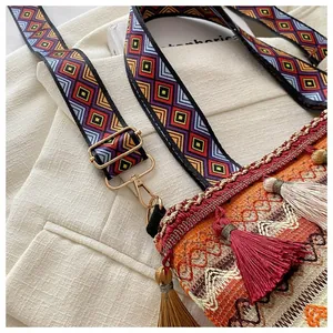 Detail of bohemian woven bag featuring colorful embroidery patterns and long tassels