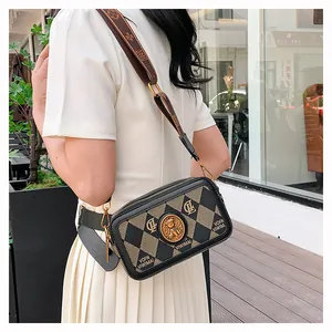 Elegante borsa a tracolla da donna con tracolla larga in un ambiente da caffè all'aperto