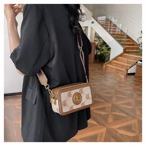Dettaglio macro della borsa a tracolla alla moda con pelle a contrasto e logo a motivo