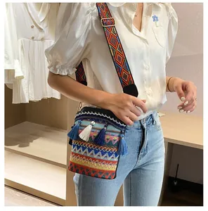Dettagli del ricamo sulla tracolla della borsa boho con nappe blu e motivo etnico
