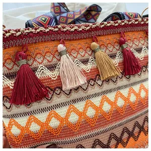 Detailed close-up of bohemian woven crossbody bag featuring colorful tassels and ethnic patterns