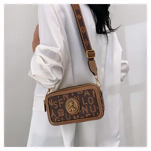 Dettaglio borsa a tracolla marrone con motivo stampato e ampia tracolla in jacquard