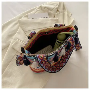 Detailed view of bohemian woven bag with colorful geometric patterns and decorative tassels